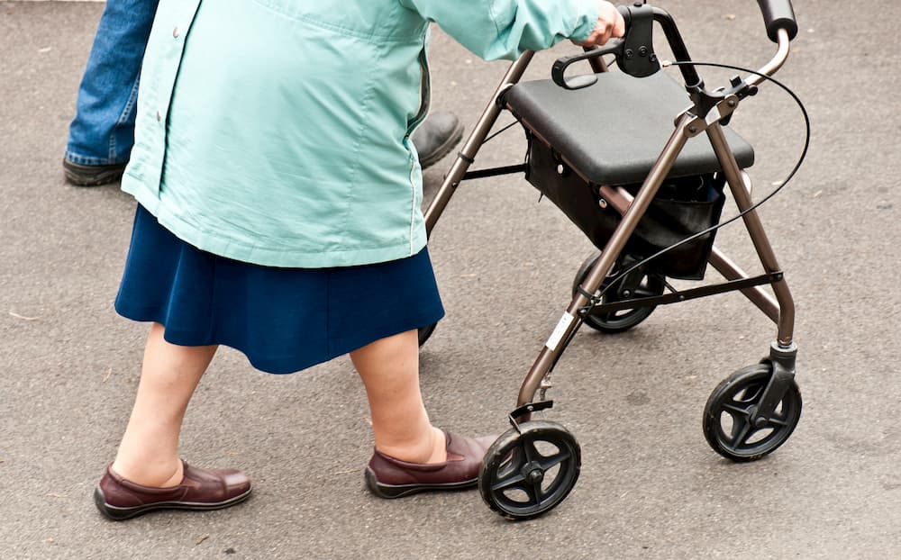 Senior lady walking with a mobility aid